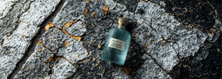 my Geisha Cannabis Lost Island The new fragrance in a  blue bottle with a label on a textured stone surface
