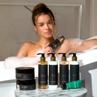 Woman in a bathtub with various my Geisha bath & body products on a marble tray.