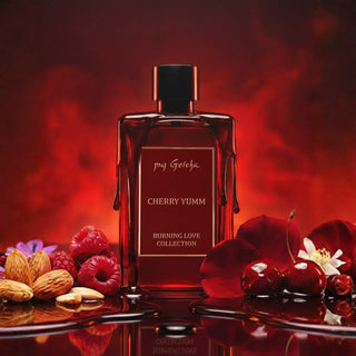 Perfume bottle labeled 'Cherry Yumm' from the 'Burning Love Collection' with cherries and almonds on a red background.