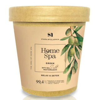 A container of Stara Mydlarnia Greek Bath Salt with a beige label and green olive branch imagery, indicating a spa-like product intended for relaxation and detoxification.