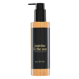 A bottle of my Geisha Jasmine in the Sun shimmering body lotion. The product features a black pump dispenser and a black label with gold lettering, framed by a warm peach-colored translucent plastic at the top and bottom, set against a plain white background.