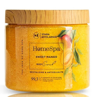 A jar of Stara Mydlarnia Mango Body Scrub with a wooden lid, predominantly yellow in color with an image of a mango and leaves on the label.