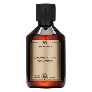 A bottle of Stara Mydlarnia Sandalwood Massage Oil with a dark cap and a label that includes the product name and the claim of being 99% natural.